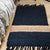 Black mat with fringe . Jute with natural stripe